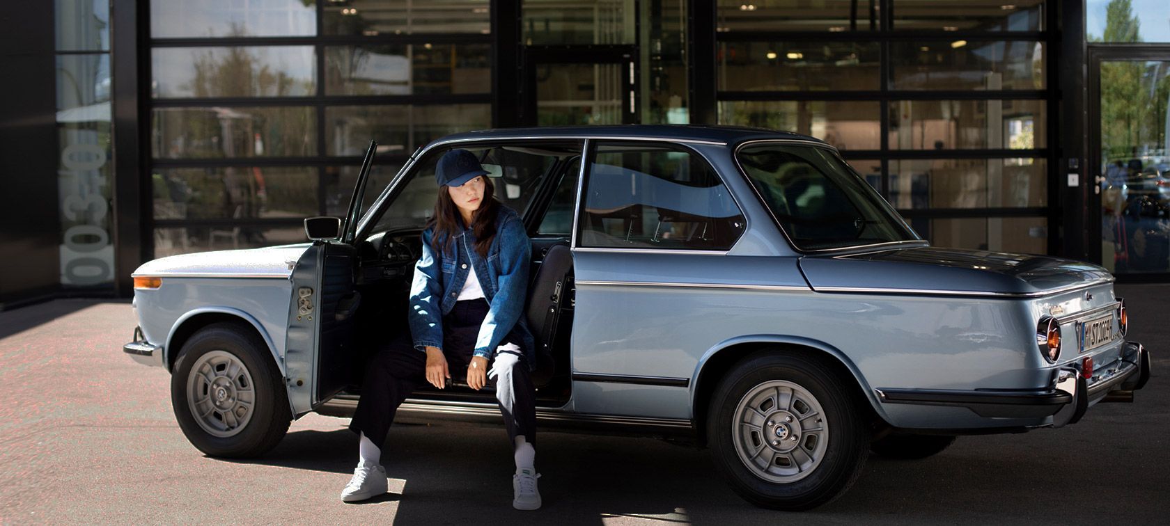 Lány BMW Lifestyle kollekciós ruházatban ül egy BMW-ben